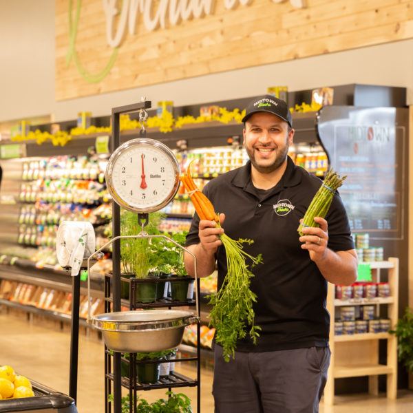 Midtown Fresh Market owner with fresh carrots and asparagus